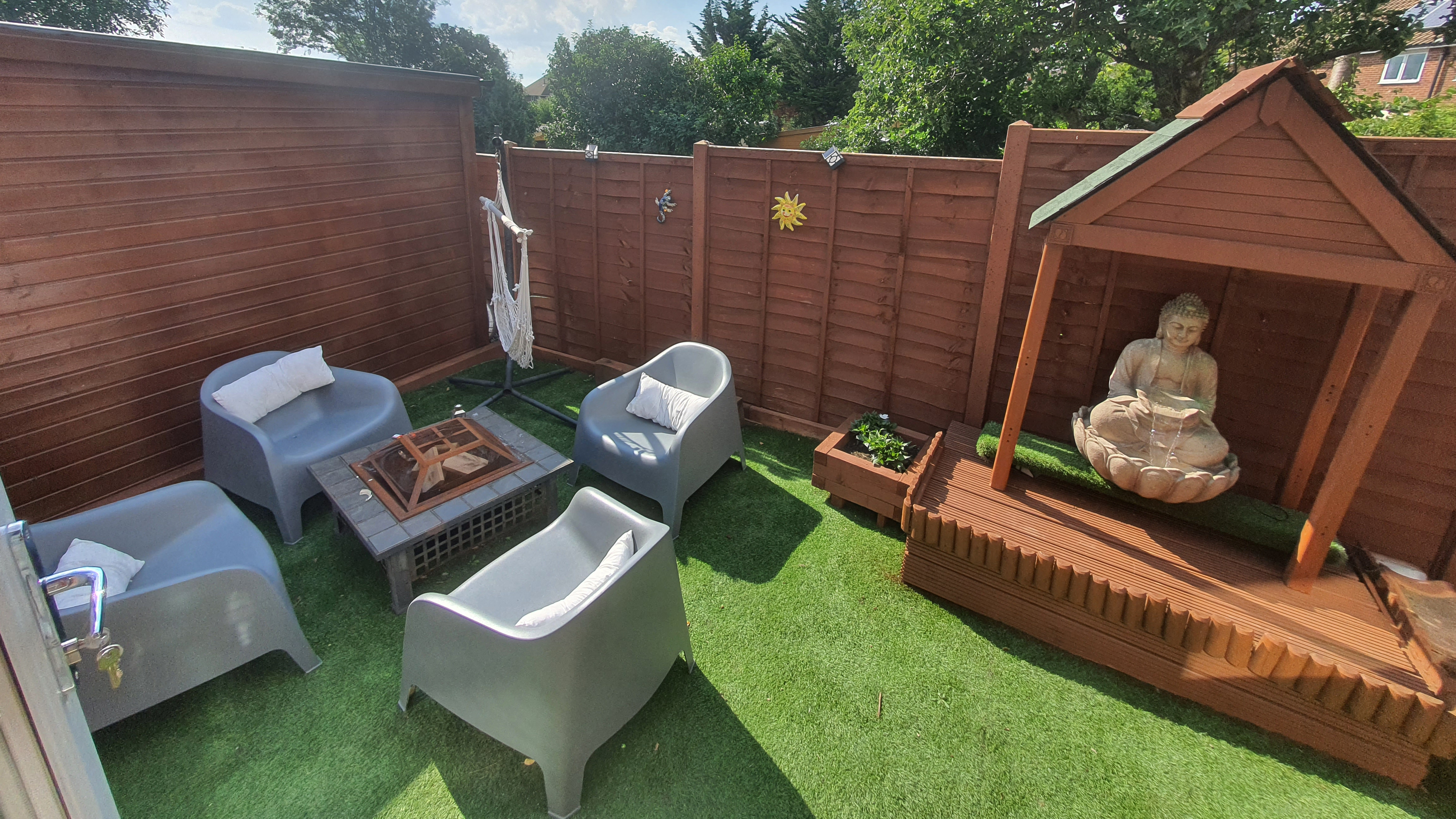 Fencing, little hut, and a fire pit within a seating area