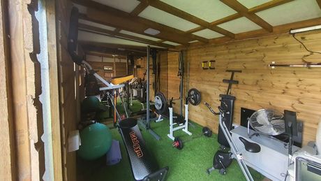 Outdoor shed turned into an insulated building to host a home gym.